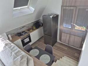 a small kitchen with a refrigerator and a table and chairs at Nektarios Bulus in Kernen