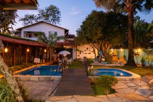 a resort with a pool and a house at Pousada das Orquídeas in Pirenópolis