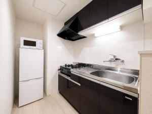 a kitchen with a sink and a refrigerator at Glory 豊平 -FIX HOME- in Sapporo +17 photos