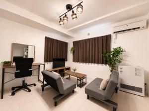 a living room with a desk and chairs and a table at Glory 豊平 -FIX HOME- in Sapporo