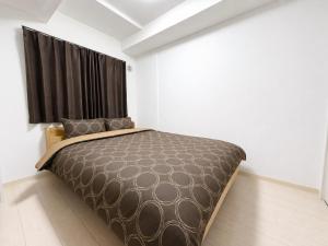 a bedroom with a bed with a black curtain at Glory 豊平 -FIX HOME- in Sapporo