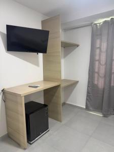 a desk with a monitor and a computer on it at Hotel Boutique Trinitarias in Valledupar