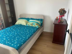 a bed with blue sheets and pillows on it at Apartamenty Leszczynowa in Łomża