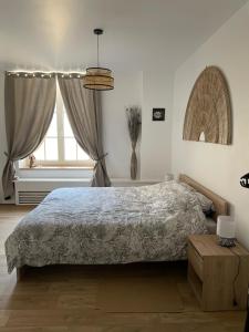 a bedroom with a bed and a window at L'Ecrin du Chalet d'Arguel in Pugey