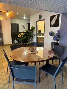 a dining room with a wooden table and chairs at L'Ecrin du Chalet d'Arguel in Pugey