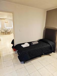 a bedroom with a black bed in a room at departamento Malbec cosecha 17 in Ciudad Lujan de Cuyo