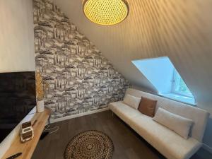 a living room with a couch and a window at La Cabane Perchée in Saint-Brieuc
