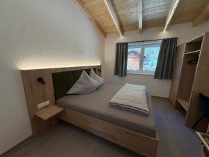 a bed in a small room with a window at 6444 Apartment in Unterlängenfeld