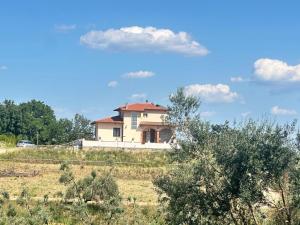 a house on top of a hill in a field at La tenuta di Greta in Canino