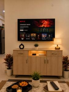 a living room with a flat screen tv on the wall at The Azure Loft Nestory Stays in Rājpur