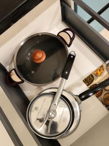 a pot on a stove top with a wooden lid at The Azure Loft Nestory Stays in Rājpur +10 photos