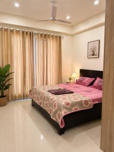 a bedroom with a large bed with a pink bedspread at The Azure Loft Nestory Stays in Rājpur