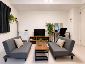 a living room with two chairs and a coffee table at Glory 豊平 -FIX HOME- in Sapporo