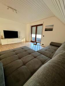 a living room with a large bed and a flat screen tv at FeWo Ruf in Sasbach am Kaiserstuhl