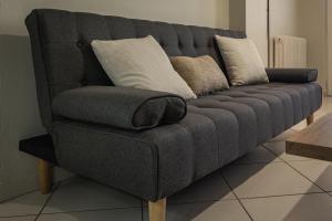 a gray couch with pillows on it in a living room at Casa Panorama in Igoumenitsa +27 photos