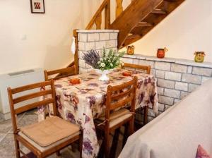 a dining room table with a vase of flowers on it at Dreamcatcher Maizonette No. 3 in Kalavrita
