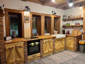 a large kitchen with wooden cabinets and a sink at Chata Salamandra in Michalovce