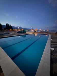 a swimming pool with blue water at night at Nomad Resort Cholpon-Ata in Cholpon-Ata