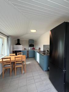 a kitchen with a table and a black refrigerator at Arctic Motel and Kautokeino Camping in Kautokeino