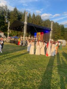 a group of people in white dresses standing under a tent at Pensiunea Trei Ponei in Corbeni