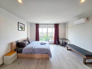 a bedroom with a bed and a desk and a window at Sena living Tiwanon Rd in Ban Bang Kradi (1)