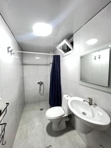 a bathroom with a toilet and a sink at Casa Bianca Kobuleti in Kobuleti