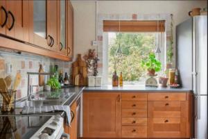 a kitchen with wooden cabinets and a sink and a window at Villa in Gothenburg in Gothenburg +2 photos