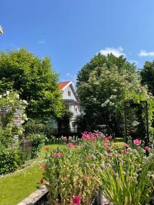 a garden with pink flowers in front of a house at Villa in Gothenburg in Gothenburg