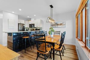 a kitchen and dining room with a wooden table and chairs at Hauts-bois Ski Inout 2brs Wpool Access 193-1 in Mont-Tremblant