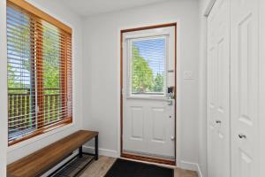a hallway with a white door and a bench next to a window at Hauts-bois Ski Inout 2brs Wpool Access 193-1 in Mont-Tremblant