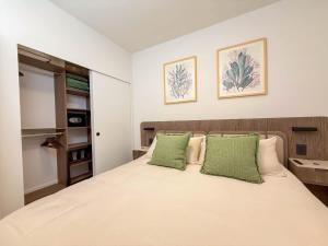 a bedroom with a large bed with green pillows at Luxury View-Walk to beach! in Miami Beach
