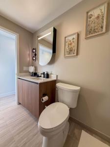 a bathroom with a toilet and a sink and a mirror at Luxury View-Walk to beach! in Miami Beach +30 photos