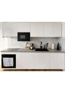 a white kitchen with white cabinets and a sink at YourHome 2 in Haigerloch +4 photos