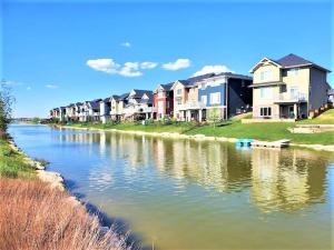 a row of houses on the side of a river at Plush Suite Pet Friendly 326 Mbps Wi-Fi in Airdrie