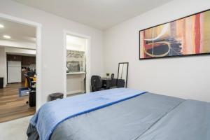 a bedroom with a bed and a painting on the wall at Plush Suite Pet Friendly 326 Mbps Wi-Fi in Airdrie