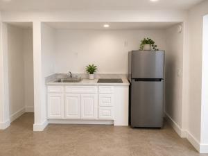 a kitchen with a stainless steel refrigerator and a sink at Sun Valley Motel in Phoenix +12 photos