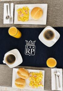 a table with plates of food and cups of coffee at Regency Plaza Hotel in Pisco