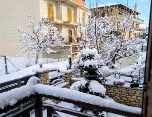 a snow covered yard with trees and a building at Dreamcatcher Maizonette No. 3 in Kalavrita