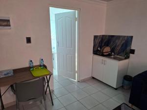 a kitchen with a table and a door leading into a room at Mypeace Comfort in Pretoria