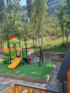 two children playing on a playground in a park at Royal Park in Arslanbob
