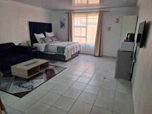 a living room with a bed and a tv in it at Mypeace Comfort in Pretoria