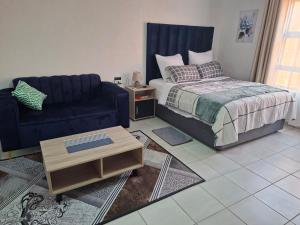 a living room with a bed and a couch at Mypeace Comfort in Pretoria