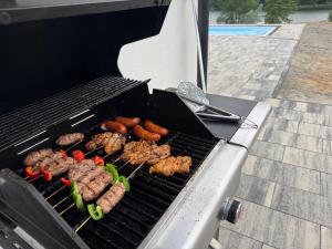 a grill with meat and vegetables on it at Dom z Widokiem in Łączonek