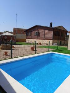 a blue swimming pool in front of a house at Casa Castro de Acebal in Villamayor de Campos