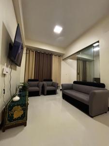 a living room with couches and a flat screen tv at 8 Newtown Mactan in Pajo