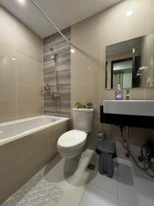 a bathroom with a toilet and a tub and a sink at 8 Newtown Mactan in Pajo +8 photos