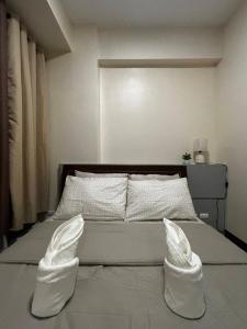 a bedroom with a bed with white shoes on it at 8 Newtown Mactan in Pajo