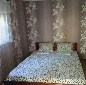 a bedroom with a bed with two pillows at Валентина in Kurortne
