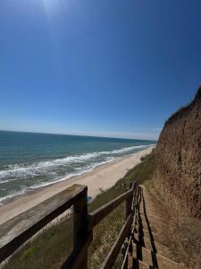 a beach with a wooden fence next to the ocean at Валентина in Kurortne