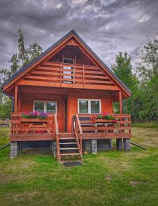 a cabin with a porch and flowers in the yard at FreeDom House in Dolina